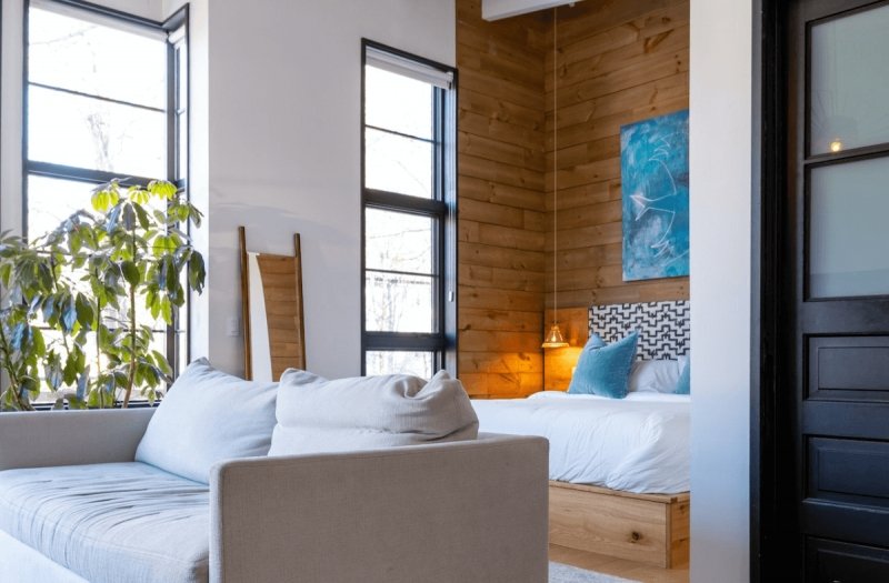 Image is showing the bedroom and living space of a modern Airbnb apartment.